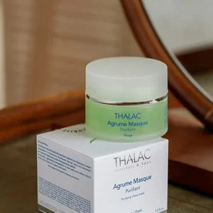 Pot de masque agrume vert avec couvercle blanc posé sur sa boite en carton blanche