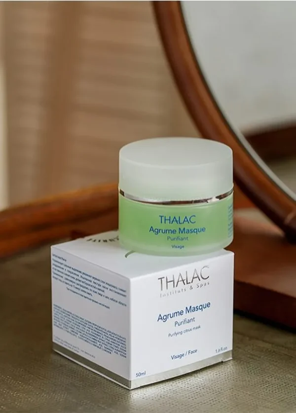 Pot de masque agrume vert avec couvercle blanc posé sur sa boite en carton blanche