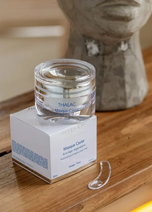 Pot transparent de masque caviar anti-age posé sur sa boite en carton blanche