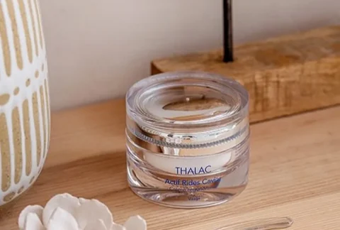 Pot transparent sur une table en bois avec une sculpture de poisson en bois à côté
