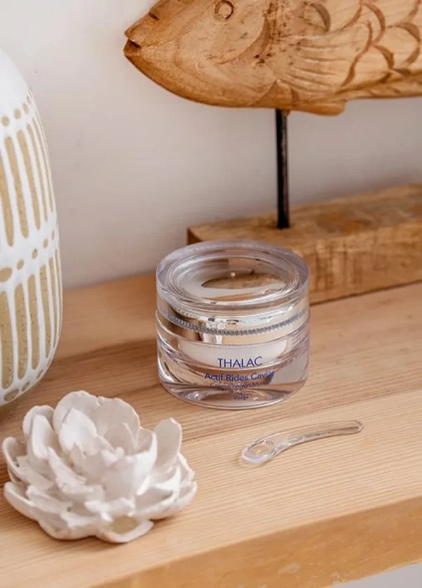 Pot transparent sur une table en bois avec une sculpture de poisson en bois à côté