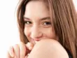 Femme souriante avec les cheveux bruns lisses et l'épaule dénudé