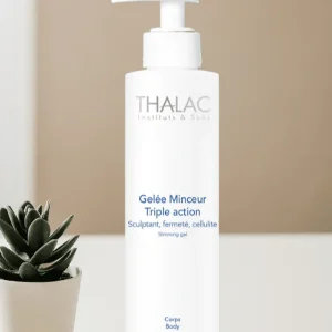 Flacon pousse-pousse blanc de gelée minceur triple action à côté d'une plante grasse en pot