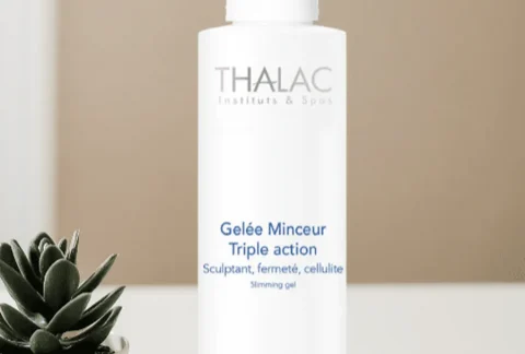 Flacon pousse-pousse blanc de gelée minceur triple action à côté d'une plante grasse en pot