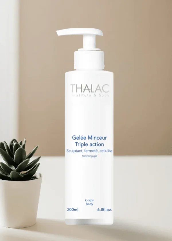 Flacon pousse-pousse blanc de gelée minceur triple action à côté d'une plante grasse en pot