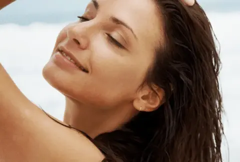 Visage éclatant de femme se tenant les cheveux