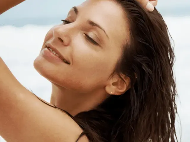 Visage éclatant de femme se tenant les cheveux