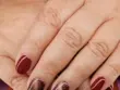 mains posées l'une sur l'uatre avec vernis rouges sur les index et auriculaire et marron sur les majeur et annulaire