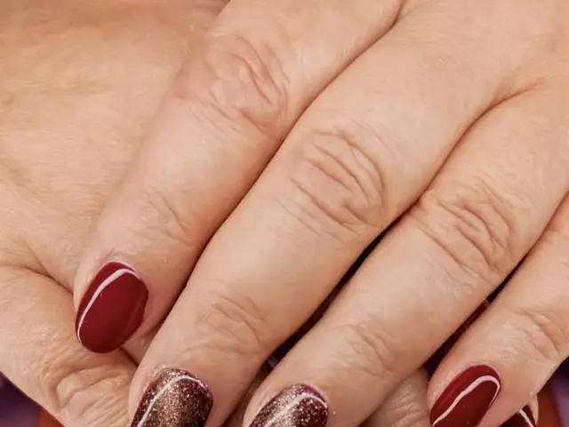 mains posées l'une sur l'uatre avec vernis rouges sur les index et auriculaire et marron sur les majeur et annulaire