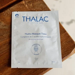 sachet blanc de hydra masque tissu au bord d'une table en bois