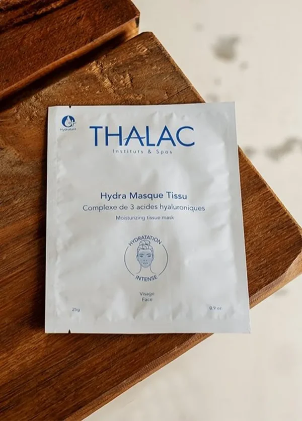 sachet blanc de hydra masque tissu au bord d'une table en bois