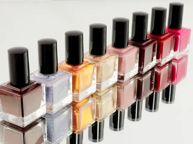 huit pots de vernis classiques avec bouchons noir en ordre de couleurs alignés