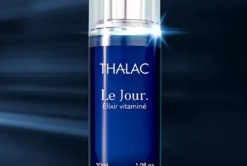 Flacon d'elixir vitaminé dans un halo de lumière bleutée