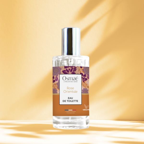Flacon de rose orientale avec bouchon argenté sur fond ocre